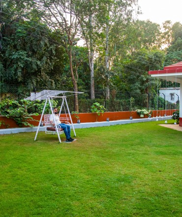 Outdoor relaxation with a swing set amongst trees and flowers
